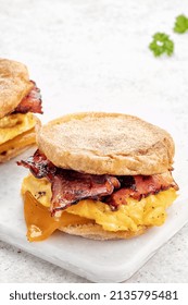 English Muffin, Scrumbled Egg, Ham, And Cheese Breakfast Sandwich On A Cutting Board