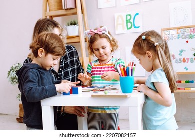 English teacher with children have fun and playing games, learning alphabet and numbers by arts in kid development childcare center. Daycare and babysitting. English school, study british and american