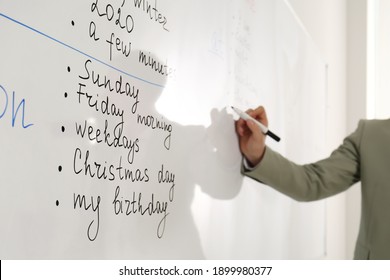 English teacher giving lesson in classroom, closeup. Focus on whiteboard