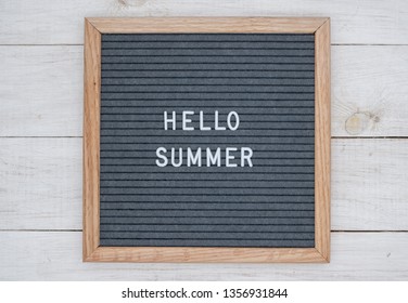 English Text Hello Summer On A Letter Board In White Letters On A Gray Background. Letter Board On White Wooden Background