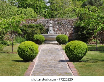 An English Walled Garden With Path Leading To A Water Feature