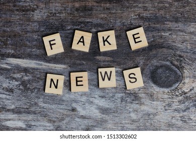 the English words - fake news - laid with wooden letters on wooden background