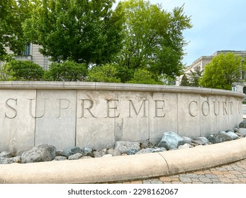 Engraved Stone in Front of the Illinois Supreme Court House that reads, "Illinois Supreme Court". Courthouse building stands behind the signage and green trees. Located in Springfield, IL, USA. - Shutterstock ID 2298162067