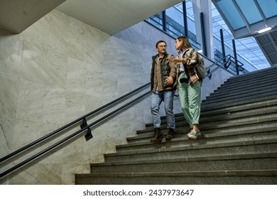 Engrossed in conversation, a couple ascends the train station stairs, the warm glow of the city illuminating their path. - Powered by Shutterstock