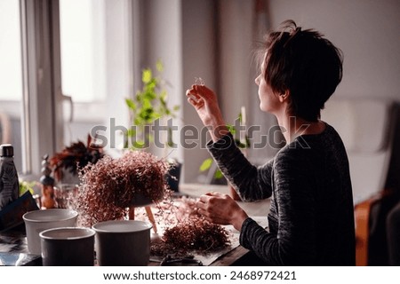 Similar – Woman with peonies on table in the living room