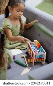 Engrossed in Play: Young Girl Playing with Wooden Elephant Whack-a-Mole Montessori Education Toy