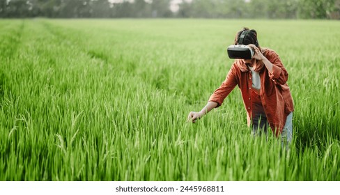 Engrossed in a virtual reality experience, a woman reaches down to touch the lush grass in a field, blending the digital and natural worlds. - Powered by Shutterstock