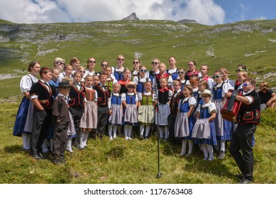 Engstlenalp, Switzerland - 4 August 2018: People wearing traditional clothes yodeling at Engstlenalp on the Swiss alps
