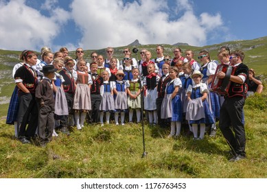 Engstlenalp, Switzerland - 4 August 2018: People wearing traditional clothes yodeling at Engstlenalp on the Swiss alps