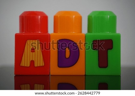 Enhanced visual focus capturing toy blocks that spell the word ADT
