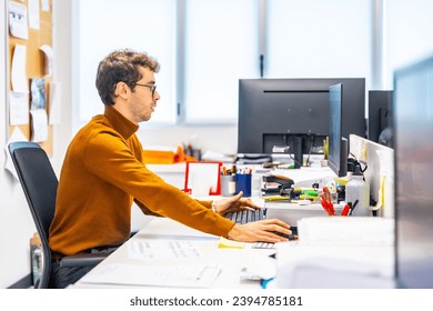 Enigneer using computer to design a metal piece in a cnc factory