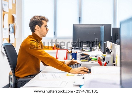 Enigneer using computer to design a metal piece in a cnc factory