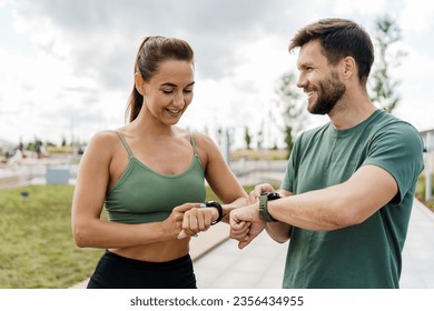 Enjoy the fitness watch and the app.  Young couple team exercises. Male and female athletes training fitness and running. People in sportswear together, physical education and sports. - Powered by Shutterstock