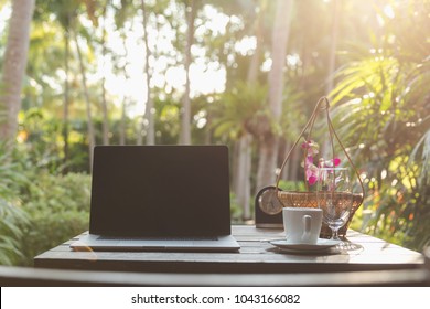 Enjoy Morning Coffee Relaxing  And Work On A Laptop In Balcony Garden Green Trees Background In The Holiday