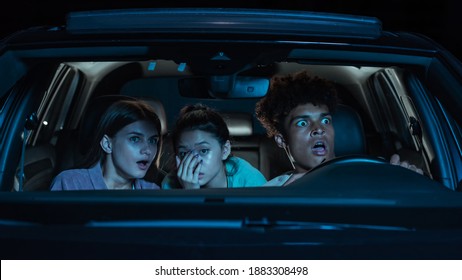 Enjoy movie. Portrait of three young friends looking emotional while sitting together in the car and watching a movie in a drive in cinema. Entertainment, leisure activities concept. Web Banner