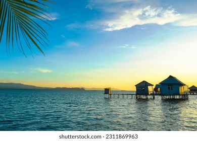 Enjoy the serene ocean ambiance as you indulge in delectable seafood dishes at a seaside restaurant during the enchanting evening hours - Powered by Shutterstock