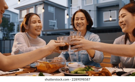 Enjoy soda drink glass toast at dine table happy hour cheers to retire middle aged mom. Group of asia people young adult woman friend and mum fun joy relax warm time night thai meal party at cozy home - Powered by Shutterstock