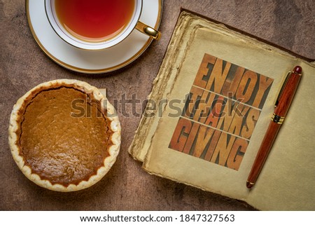 Enjoy Thanksgiving - letterpress typography in a retro, leather-bound journal with a pumpkin pie and a cup of tea, fall holiday greetings
