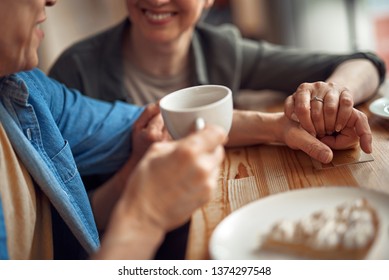 Enjoyable meeting. Close up cropped head portrait of cheerful aged woman and man looking with love to each other while holding hands in cafe - Powered by Shutterstock