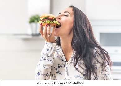 Enjoying A Bite Of A Hamburger By A Female.