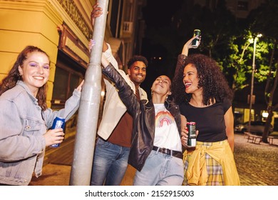 Enjoying Cold Drinks In The City. Group Of Cheerful Young Friends Smiling Happily While Holding Beer Cans. Multicultural Young People Having A Good Time Together On The Weekend.