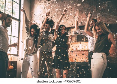 Enjoying cool party. Group of happy young people throwing confetti and jumping while enjoying home party on the kitchen  - Shutterstock ID 495639601