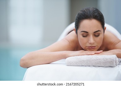 Enjoying a day at the spa. Shot of a beautiful woman lying on a poolside massage table. - Powered by Shutterstock