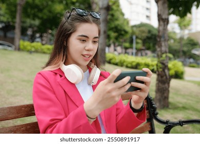 Enjoying Digital Entertainment on Smartphone Outdoors - Powered by Shutterstock