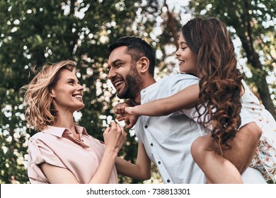 Enjoying Every Moment Together. Happy Young Family Of Three Smiling While Spending Free Time Outdoors