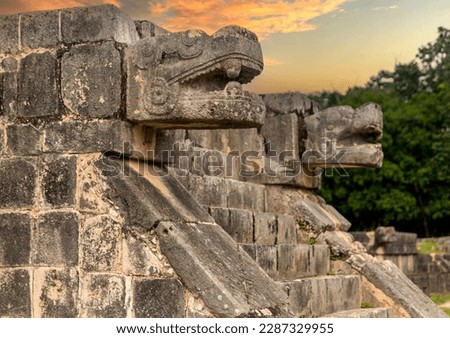 Enjoying the God Kukulkan on the platform of eagles and jaguars under a beautiful orange sunset, this is the feathered serpent of the Mayan civilization. Concept pyramid of Chichen Itza.