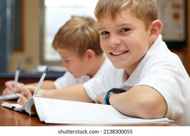 Enjoying His Learning Experience. Two Young Schoolboys Doing Their Schoolwork In The Classroom.