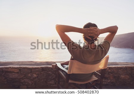 Enjoying life. Back side of young man looking at the sea, vacations lifestyle concept