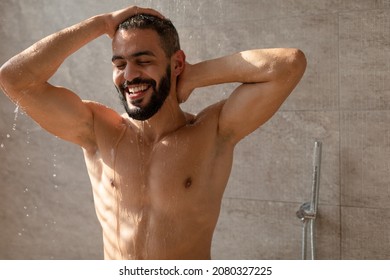 Enjoying The Morning. Portrait Of Handsome Happy Muscular Man Taking Shower Washing Head Standing Under Falling Hot Water In Modern Bathroom At Home. Male Bodycare Beauty Routine And Everyday Hygiene