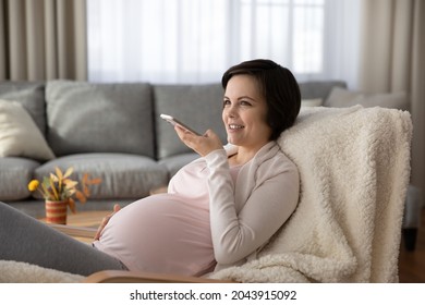 Enjoying pregnancy. Happy young future mom send voice message record audio blog on cell devoted to anticipation parenthood maternity. Positive mother to be dictate vocal letter to beloved wanted child