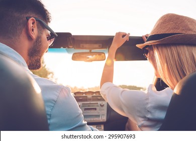 Enjoying Road Trip Together. Rear View Of Joyful Young Couple Having Fun While Riding In Their Convertible 