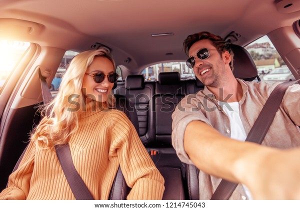 Enjoying road trip\
together.Leisure, road trip,people and travel concept -man and\
woman driving in car.