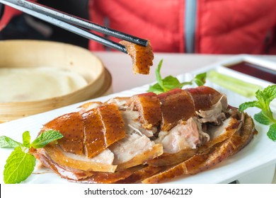 Enjoying Roasted Peking Duck In A Restaurant In Beijing