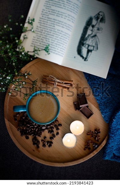 Enjoying a romantic candlelight coffee and book.\
Top view photo of coffee with chocolate, cinnamon and coffee beans\
next to filter coffee