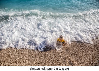 Enjoying summer and having great fun with big waves on an idyllic beach in Mediteranean