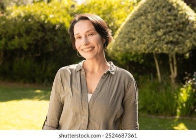 Enjoying sunny day outdoors, smiling middle-aged woman standing in garden. sunshine, nature, happiness, summertime, lifestyle, leisure - Powered by Shutterstock