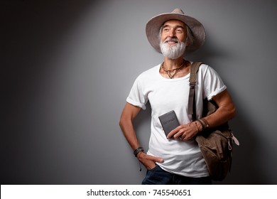 Enjoying Travel. Studio Portrait Of Handsome Senior Man With Gray Beard And Hat.