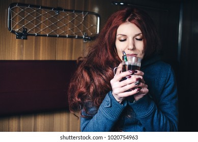 Enjoying Travel. Young Pretty Woman Traveling By The Train, Sitting Near The Window And Drink Tea.