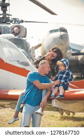 Enjoying Travelling By Air. Happy Family Vacation. Family Couple With Son On Vacation Travel. Woman And Man With Boy Child At Helicopter. Air Tour And Travel. Love Is A Family Value.