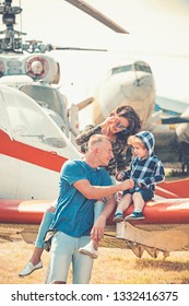 Enjoying Travelling By Air. Happy Family Vacation. Family Couple With Son On Vacation Travel. Woman And Man With Boy Child At Helicopter. Air Tour And Travel. Love Is A Family Value.