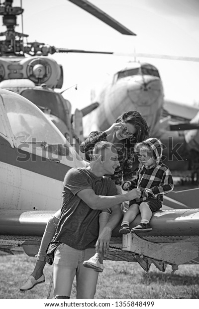 Enjoying\
travelling by air. Happy family vacation. Family couple with son on\
vacation travel. Woman and man with boy child at helicopter. Air\
tour and travel. Love is a family\
value.