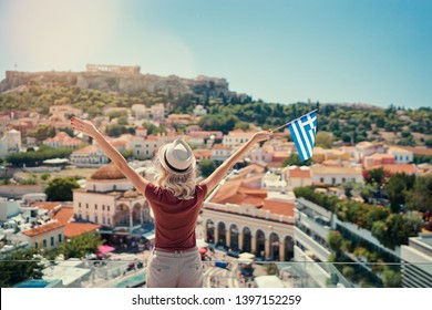 Enjoying Vacation In Greece. Young Traveling Woman With National Greek Flag Enjoying View Of Athens City And Acropolis.