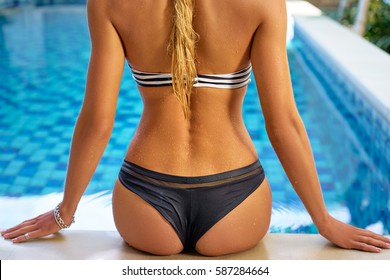 Enjoying vacation. Slim young woman in swimming pool.