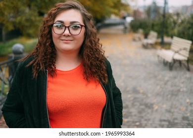 Enjoying Walk. Happy Plus Size Woman. Body Positive. Healthy Lifestyle. Smiling Fatty Lady In Sportive Clothes Spectacles On Street Alley Autumn Season Copy Space.