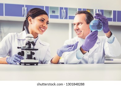 Enjoying Work. Long-haired Female Assistant Smiling Broadly While Enjoying Working With His Professional Academic Advisor