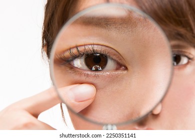 Enlarge the woman's lower eyelid with a magnifying glass.